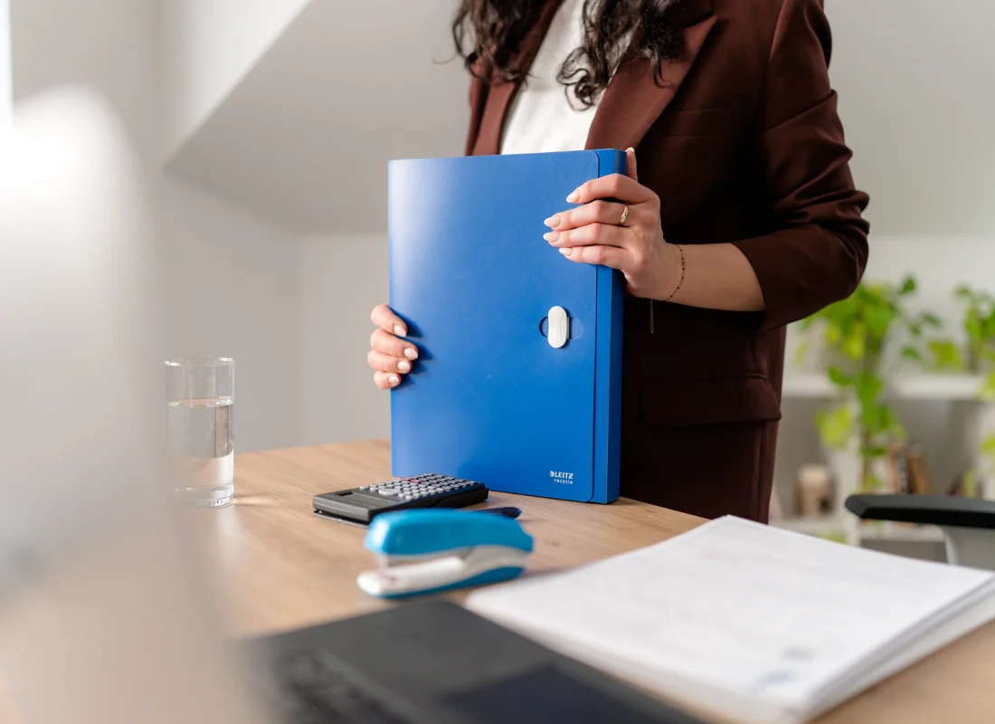 Pracownik biura rachunkowego w Mielcu trzyma segregator z dokumentami dotyczącymi zakładania działalności gospodarczej.